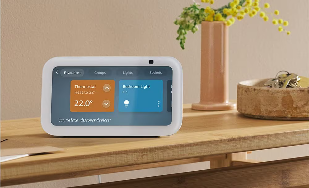 amazon echo show 5 pictured on a wooden sideboard with keys next to it