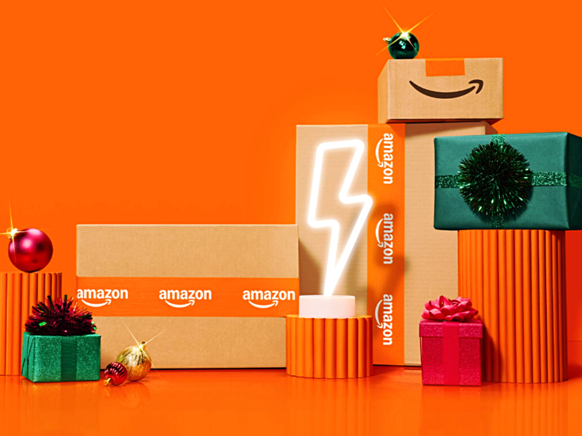 Amazon shipping boxes and gift in front of an orange background