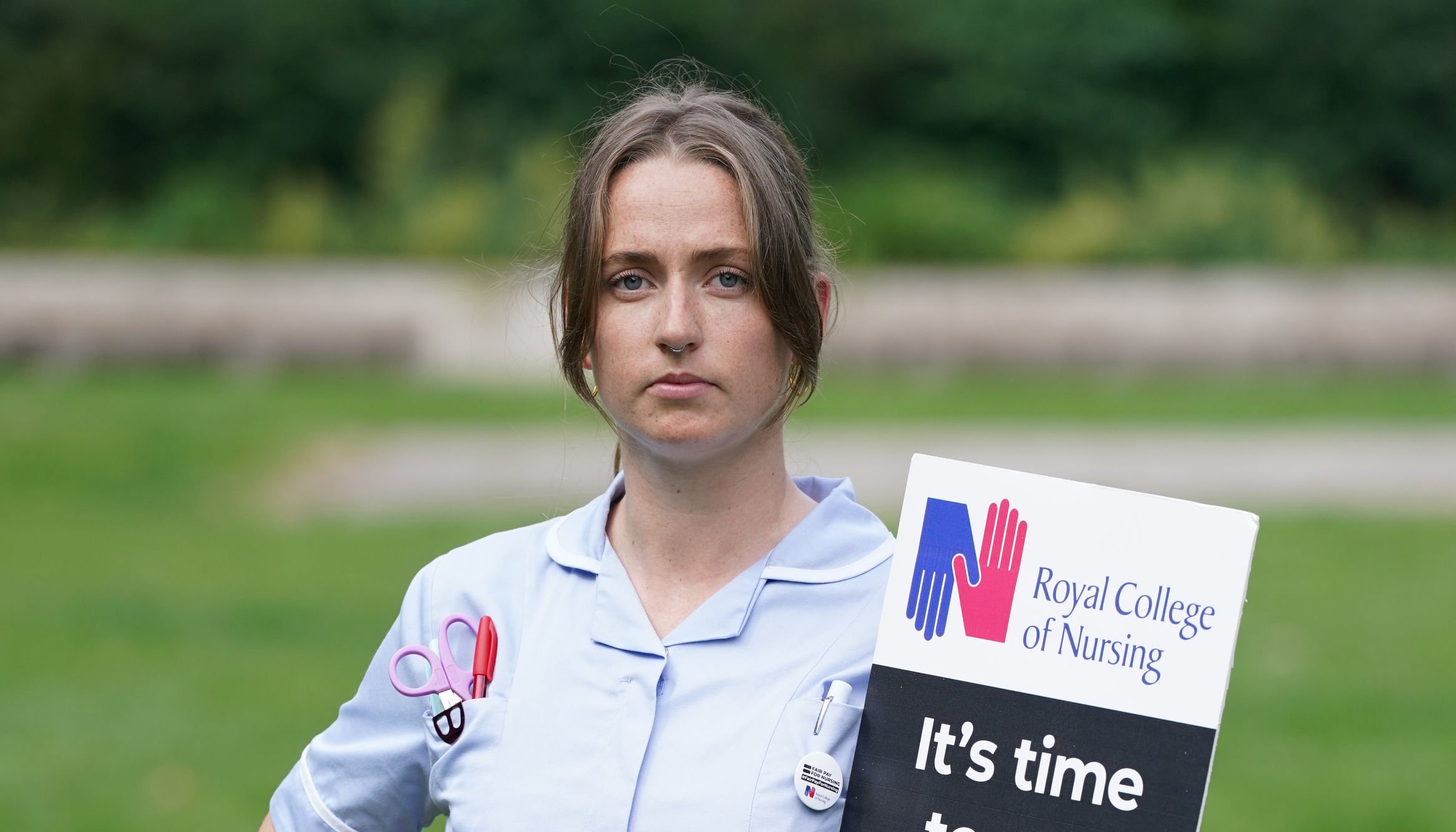 Amy Fancourt with a placard outside the Royal College of Nursing (RCN) in Victoria Tower Gardens.