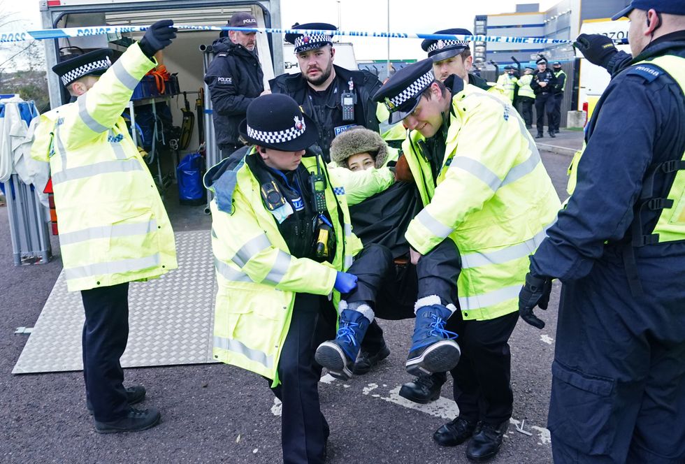 An activist from Extinction Rebellion is carried away by police after they blocked the entrance to the Amazon fulfilment centre in Tilbury, Essex, preventing lorries from entering or leaving on Black Friday, the global retail giant's busiest day of the year. Picture date: Friday November 26, 2021.