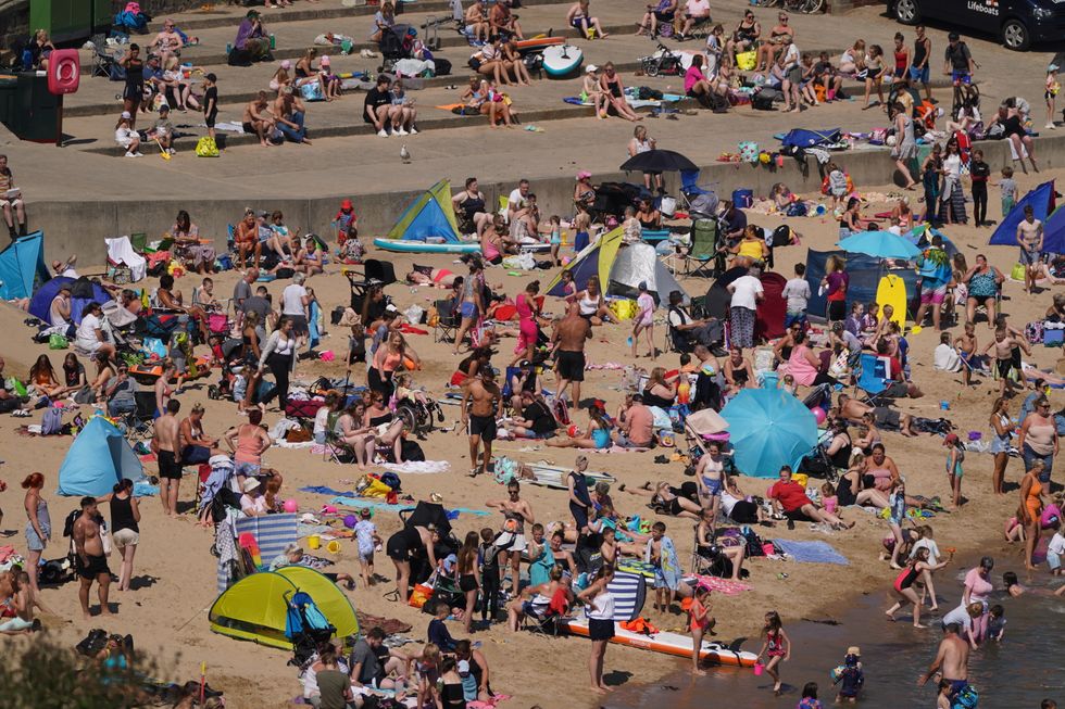 An aerial view of people enjoying the hot weather on the beach at Cullercoats Bay in North Tyneside. The Met Office has issued an amber warning for extreme heat covering four days from Thursday to Sunday for parts of England and Wales as a new heatwave looms. Picture date: Wednesday August 10, 2022.