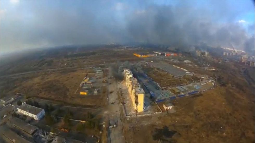 An aerial view shows smoke rising from damaged residential buildings following an explosion.