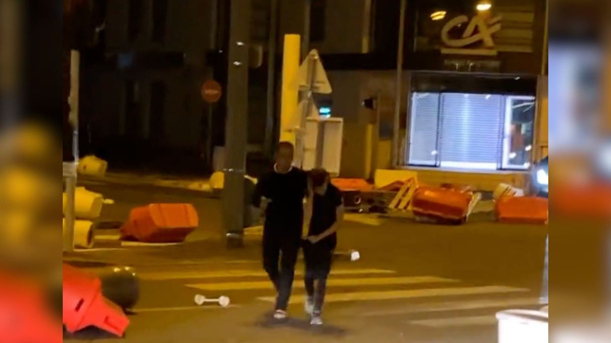 An angry father was spotted dragging a young boy who appeared to be his son away from riots before speeding off home