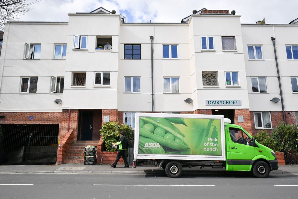 An ASDA delivery driver stacks food baskets during his rounds in Bristol as the UK enters the second week of lockdown due to the global coronavirus pandemic.