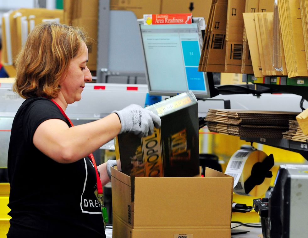 An associate packing customer orders at the Amazon fulfilment centre in Hemel Hempstead