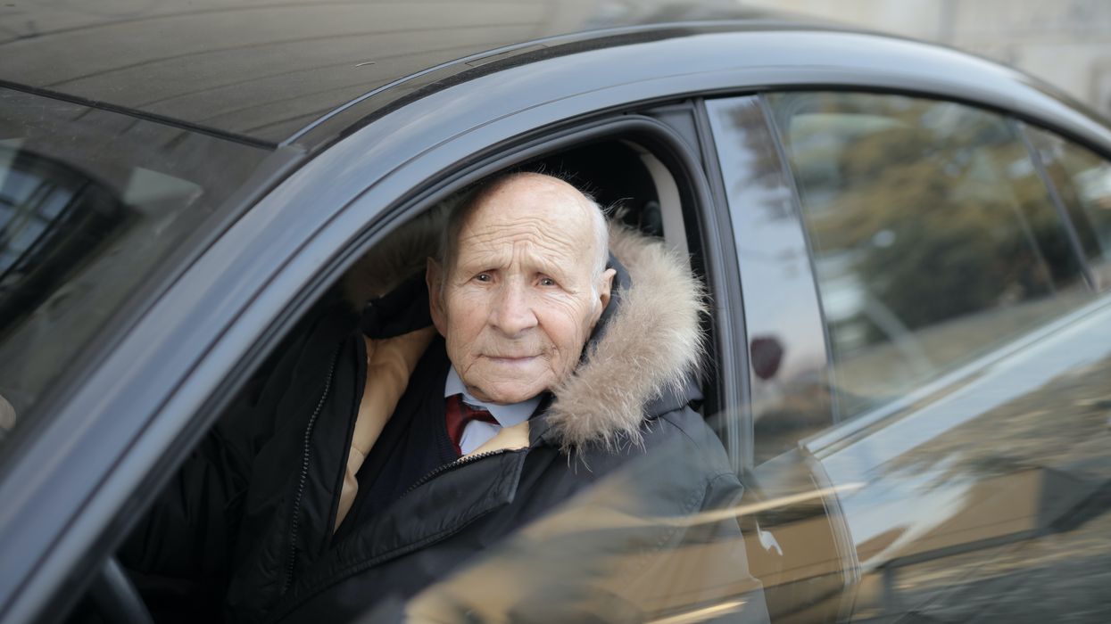 An elderly man driving a car