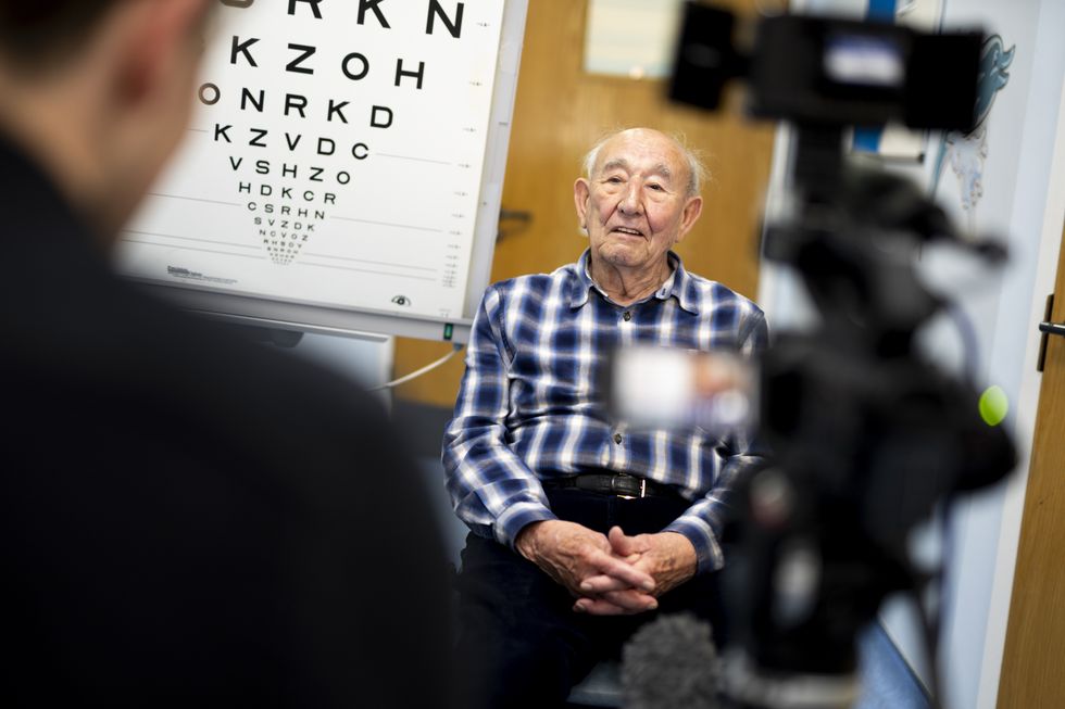 An elderly man taking an eye test