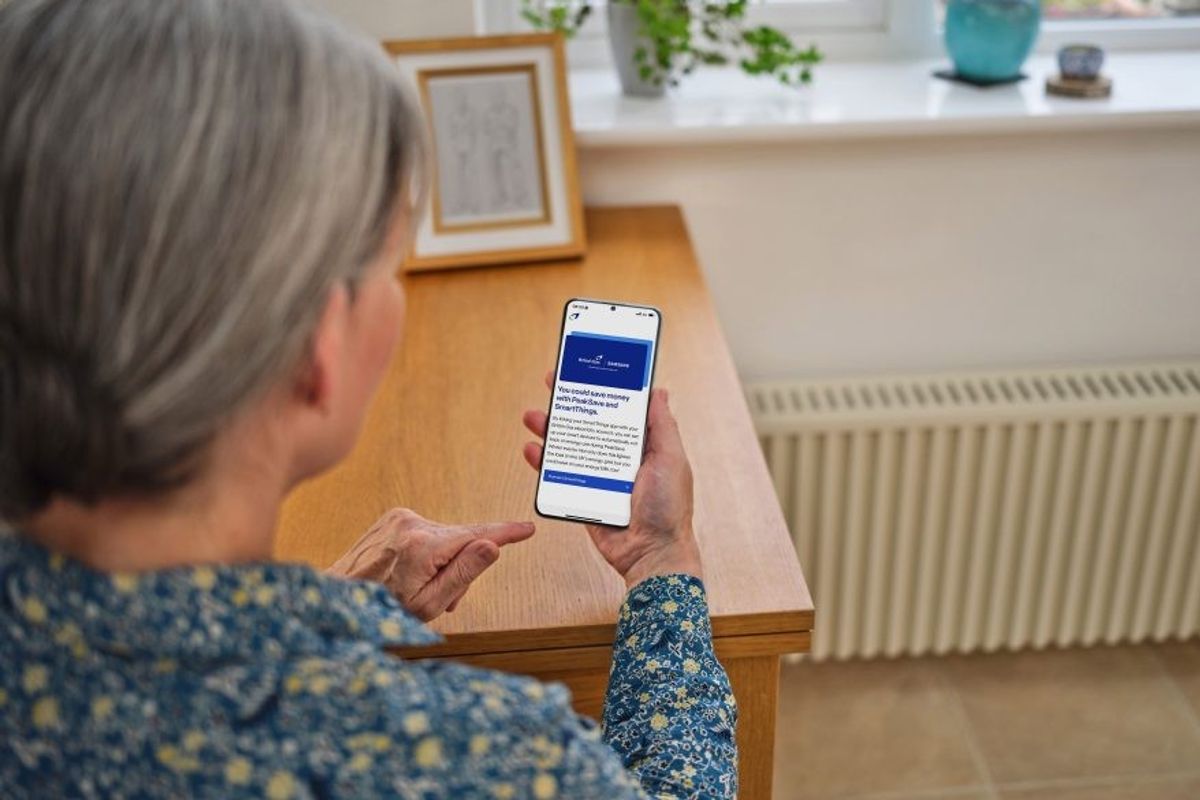an elderly woman checks the samsung smartthings app on her phone