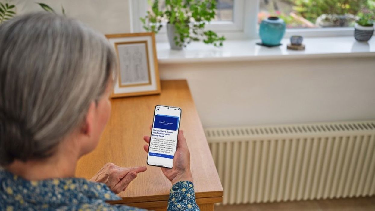 an elderly woman checks the samsung smartthings app on her phone