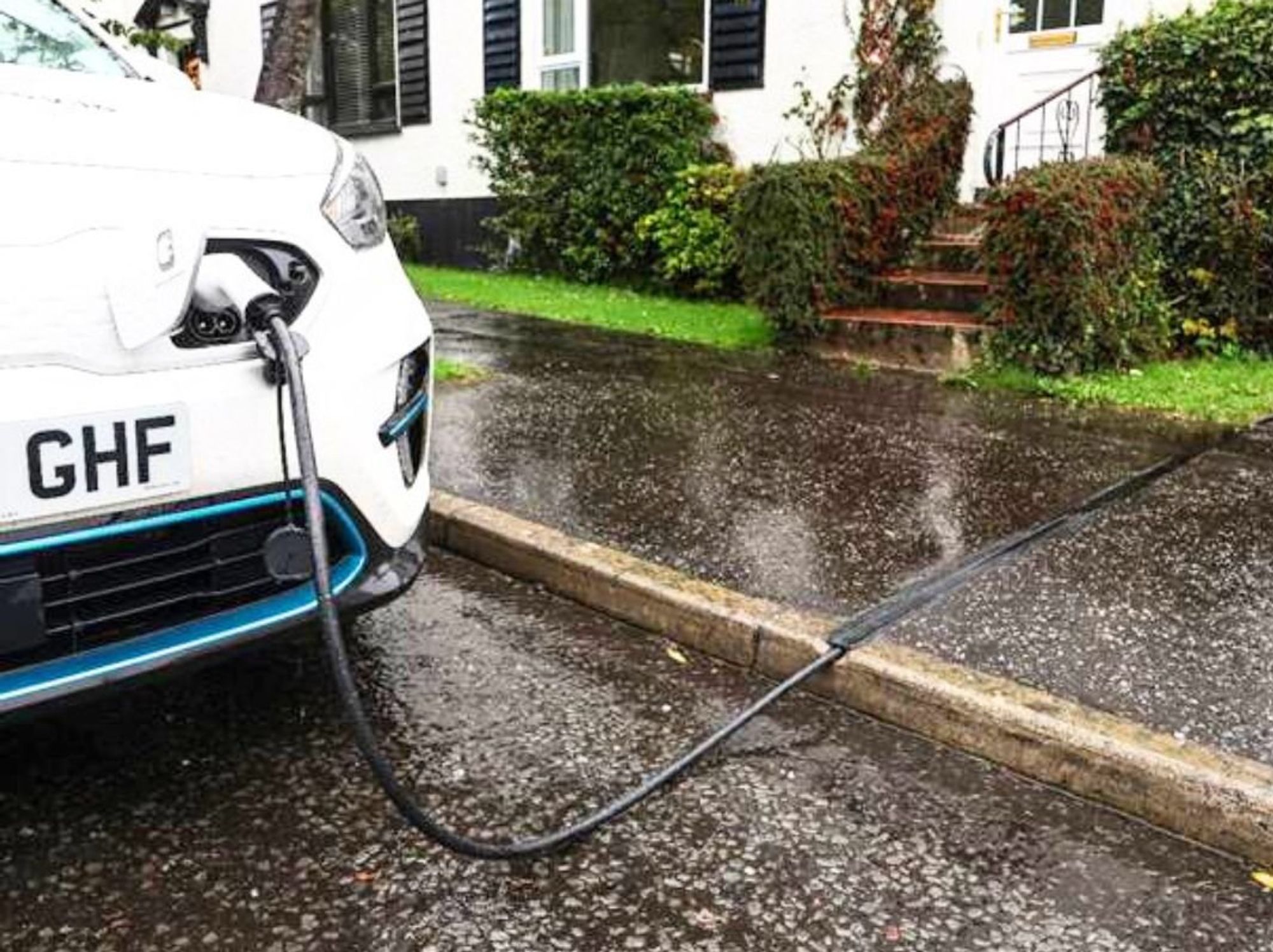 An electric car charging using a Kerbo Charge cross-pavement solution