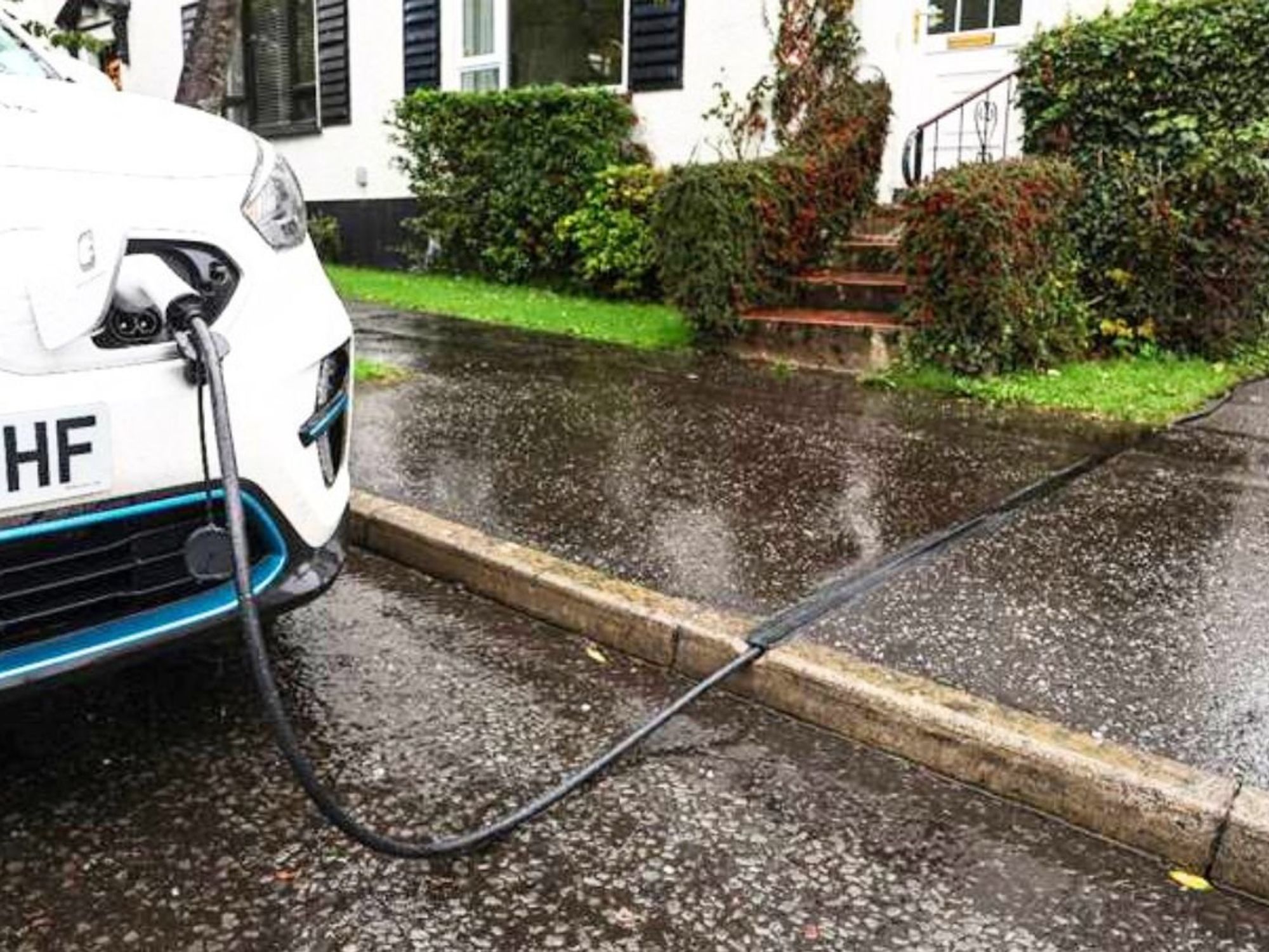 An electric car charging using a Kerbo Charge cross-pavement solution