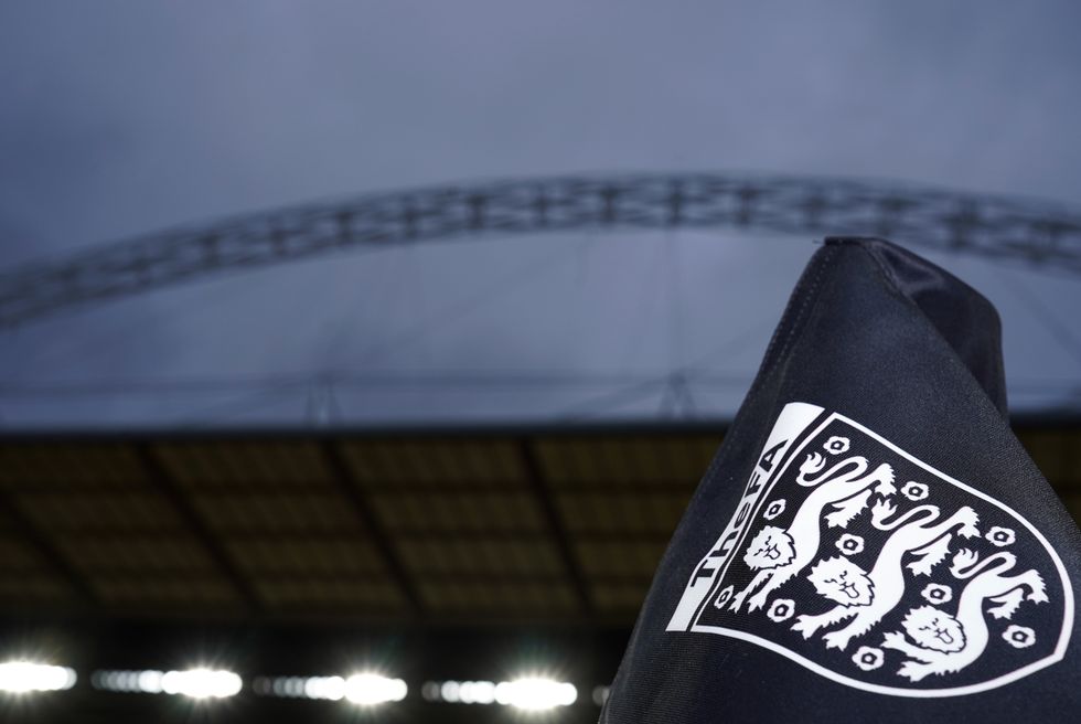 An English FA badge on a corner flag in front of the Wembley Arch