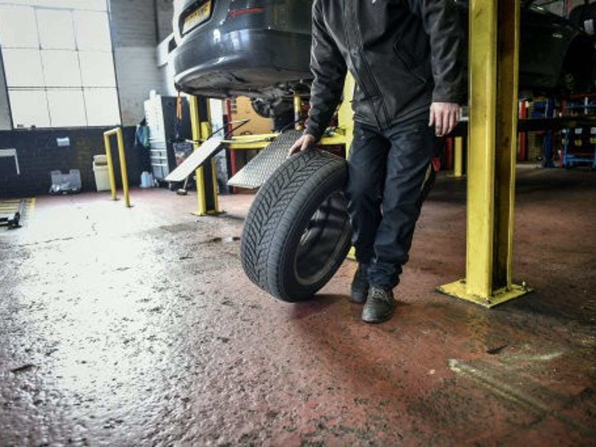 An image of a mechanic holding a tyre