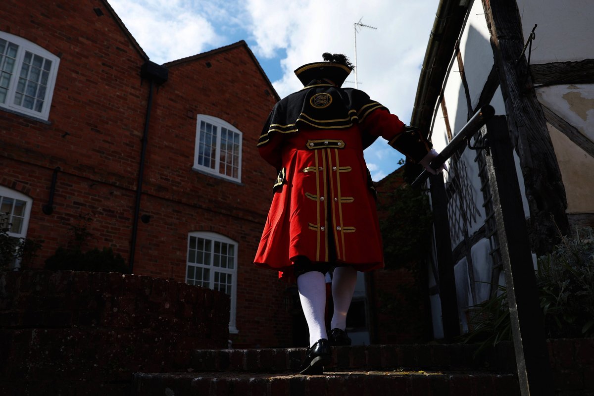 An image of a town crier wearing the red tradition costume