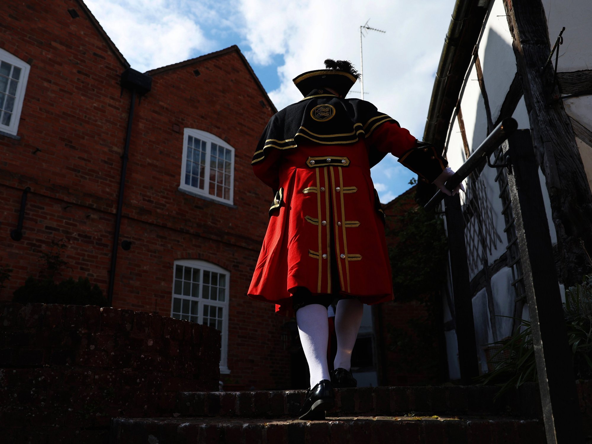 An image of a town crier wearing the red tradition costume