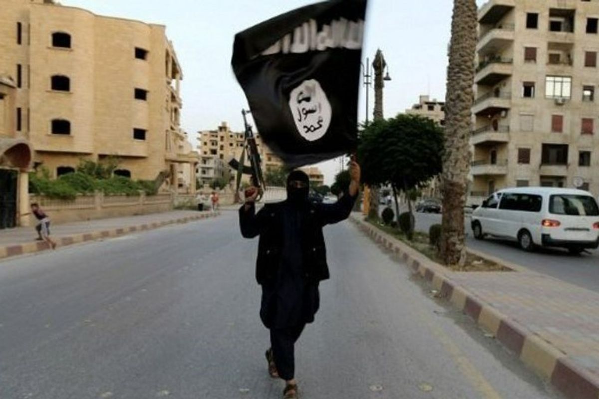 An image of an Isis fighter flying an Isis flag