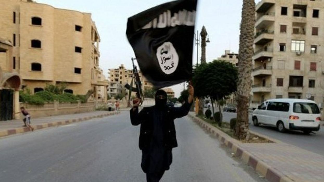 An image of an Isis fighter flying an Isis flag