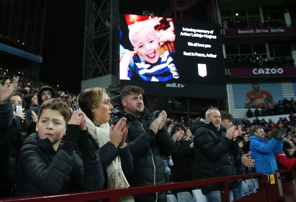 An image of Arthur Labinjo Hughes is displayed on a big screen during a minute's applause in his memory