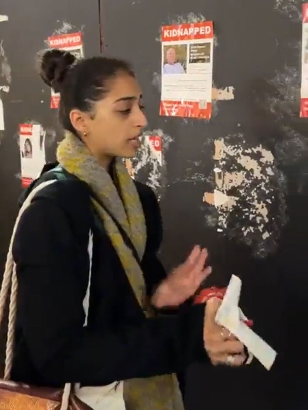 An image of one of the protesters tearing down posters