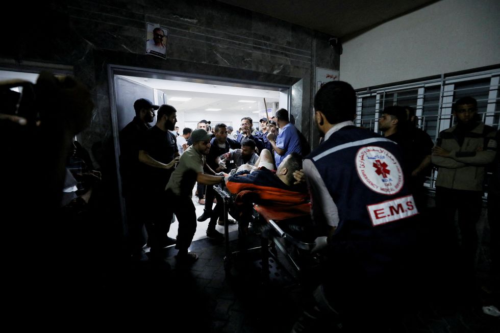 An injured person is assisted at Shifa Hospital after an Israeli air strike hit the nearby Al-Ahli Hospital