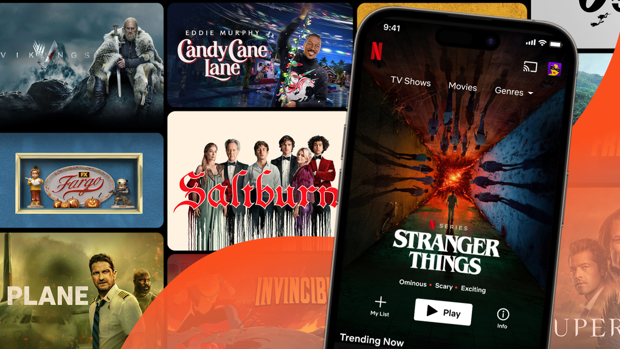 an iphone is pictured with the netflix app on-screen while a tile of artwork from amazon prime video shows can be seen in the background