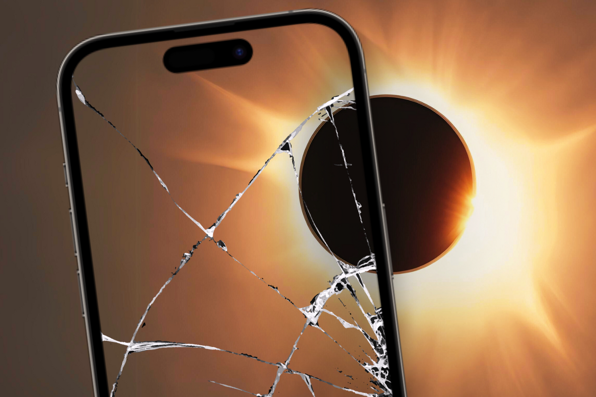 an iphone pointed at the total solar eclipse with the screen cracked 