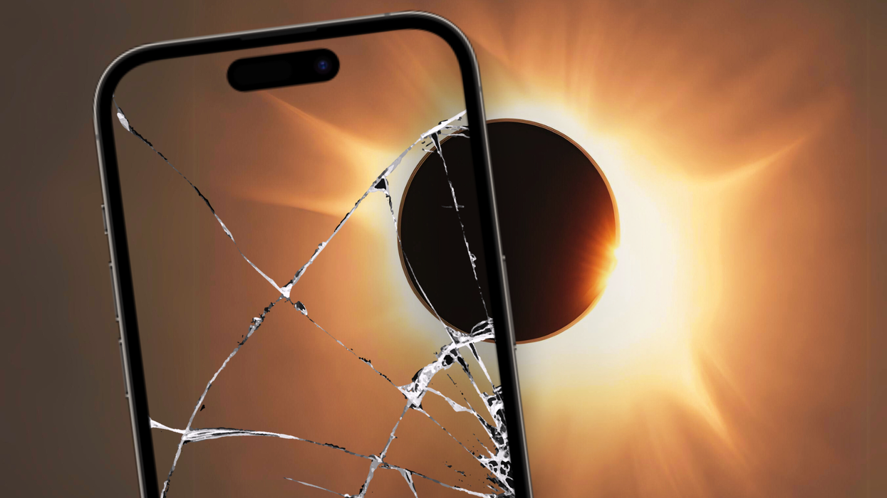 an iphone pointed at the total solar eclipse with the screen cracked