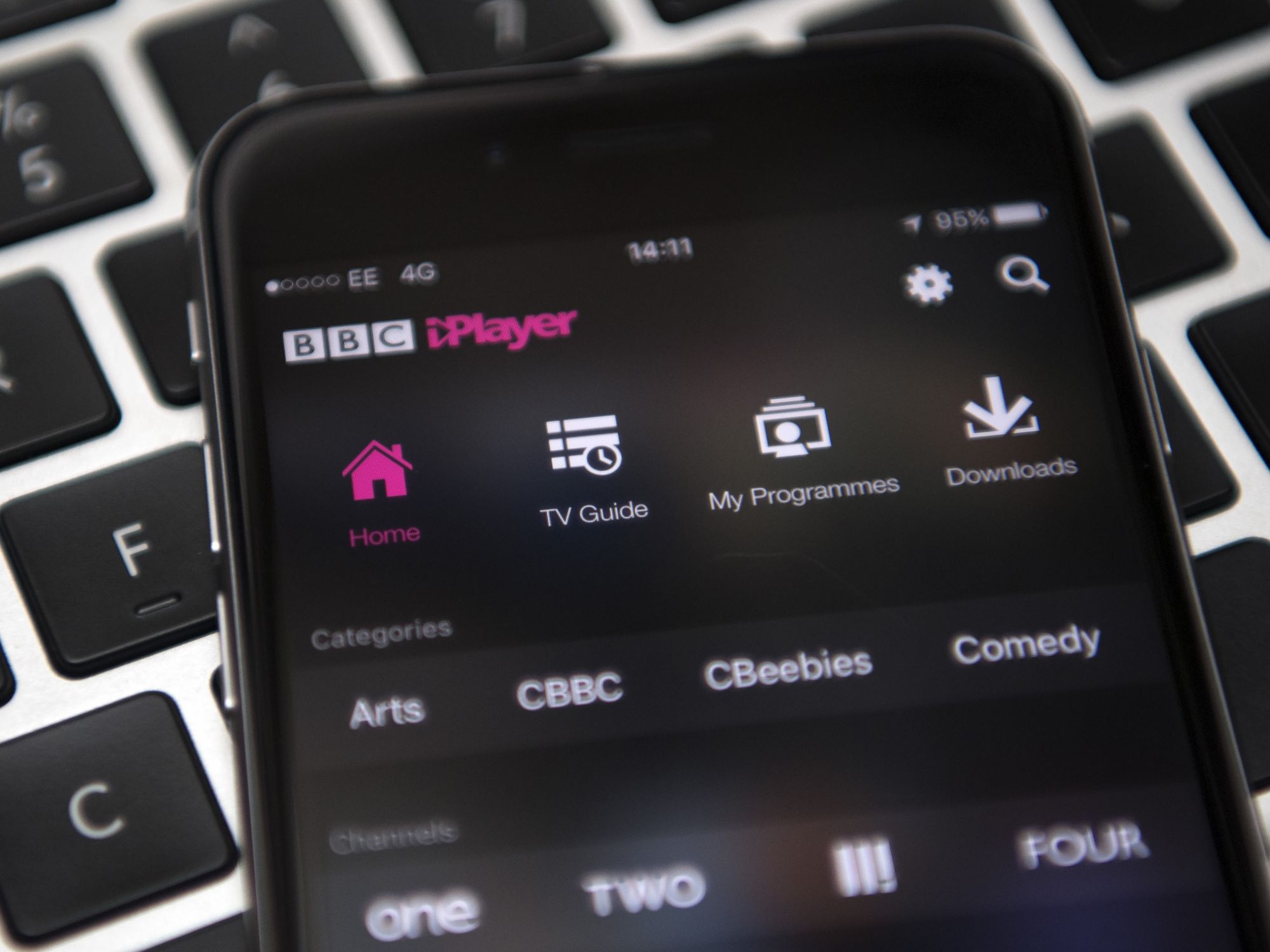 an iphone running bbc iplayer pictured lying on a keyboard