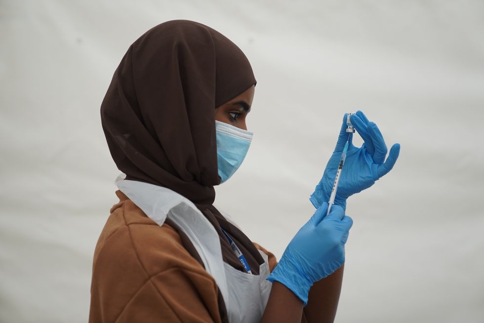 An NHS worker prepares a Covid jab at a pop-up vaccination centre.