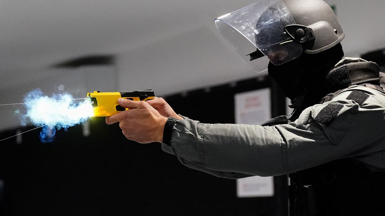 An officer using a Taser during a demonstration of the trial