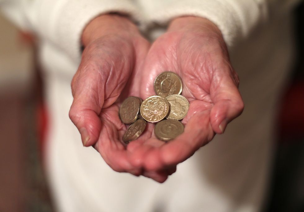 An older person holding coins in her hands