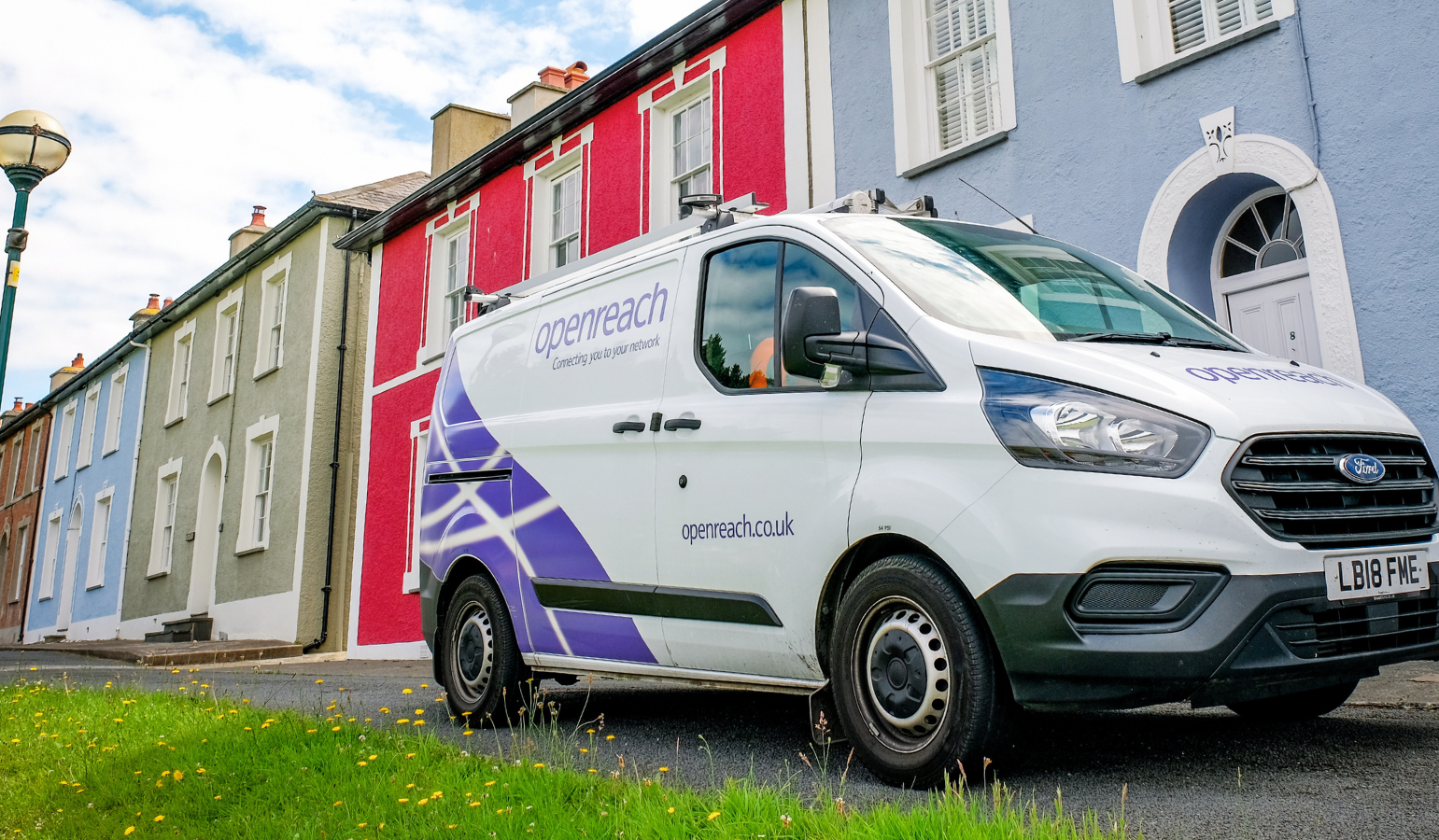 an openreach branded van is pictured parked outside a row of colourful houses
