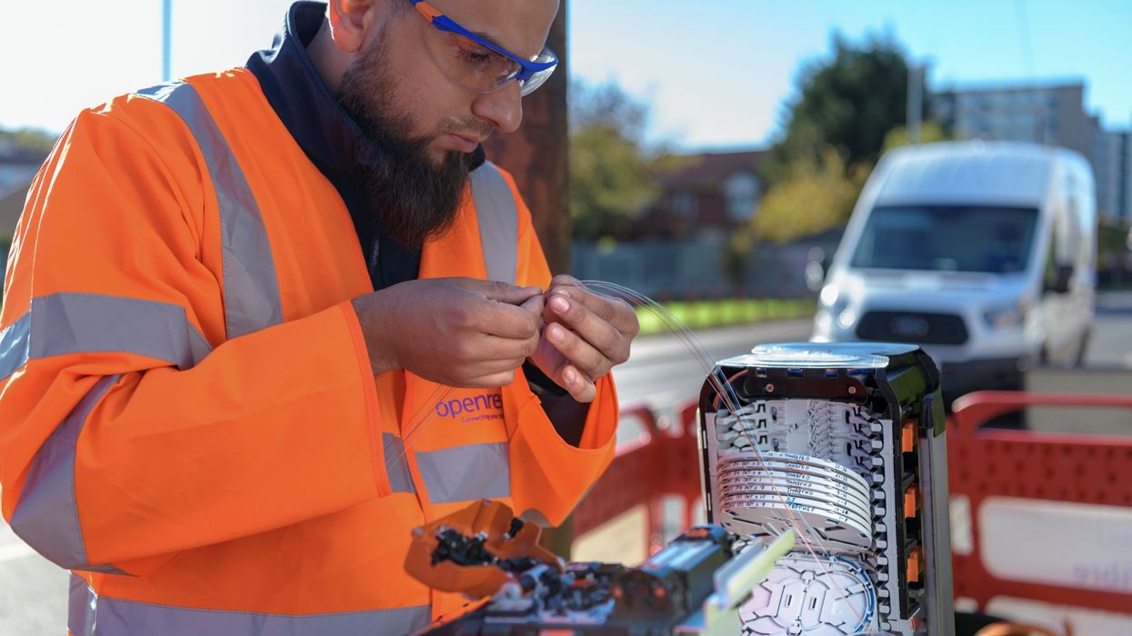 an openreach engineer is pictured holding a fibre optic cable at one of thousands of exchanges across the UK
