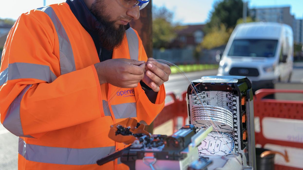 an openreach engineer wires up a fibre optic cable in an exchange cabinet