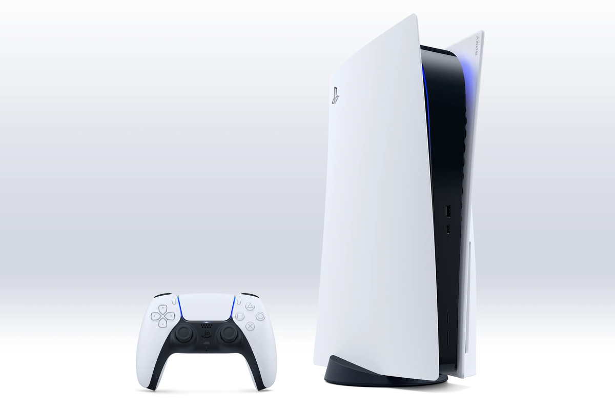 an original playstation 5 console stands next to a dualsense controller on a white background