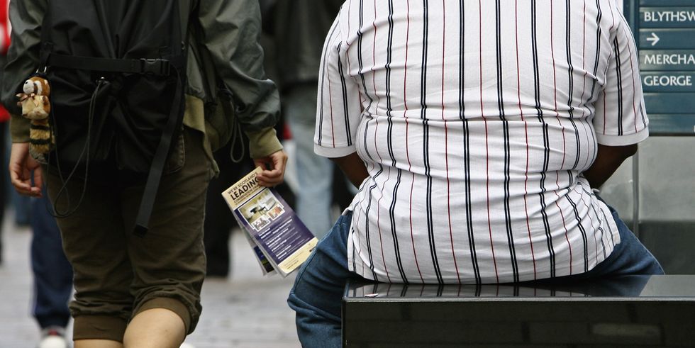 An overweight person sits on a bench in Glasgow City centre