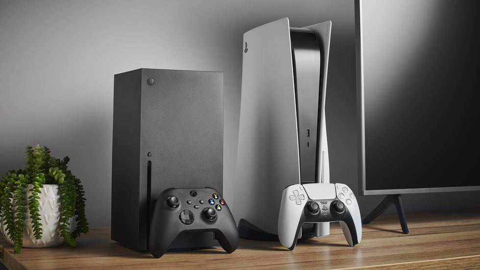 an xbox series x and sony playstation 5 pictured side by side next to a flatscreen tv