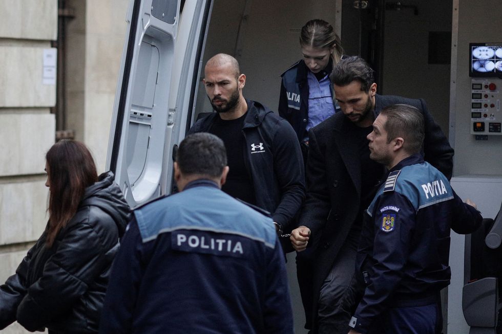 Andrew Tate and his brother Tristan are escorted by police officers outside the headquarters of the Bucharest Court of Appeal, in Bucharest, Romania, January 10, 2023. Inquam Photos/Octav Ganea via REUTERS ATTENTION EDITORS - THIS IMAGE WAS PROVIDED BY A THIRD PARTY. ROMANIA OUT. NO COMMERCIAL OR EDITORIAL SALES IN ROMANIA