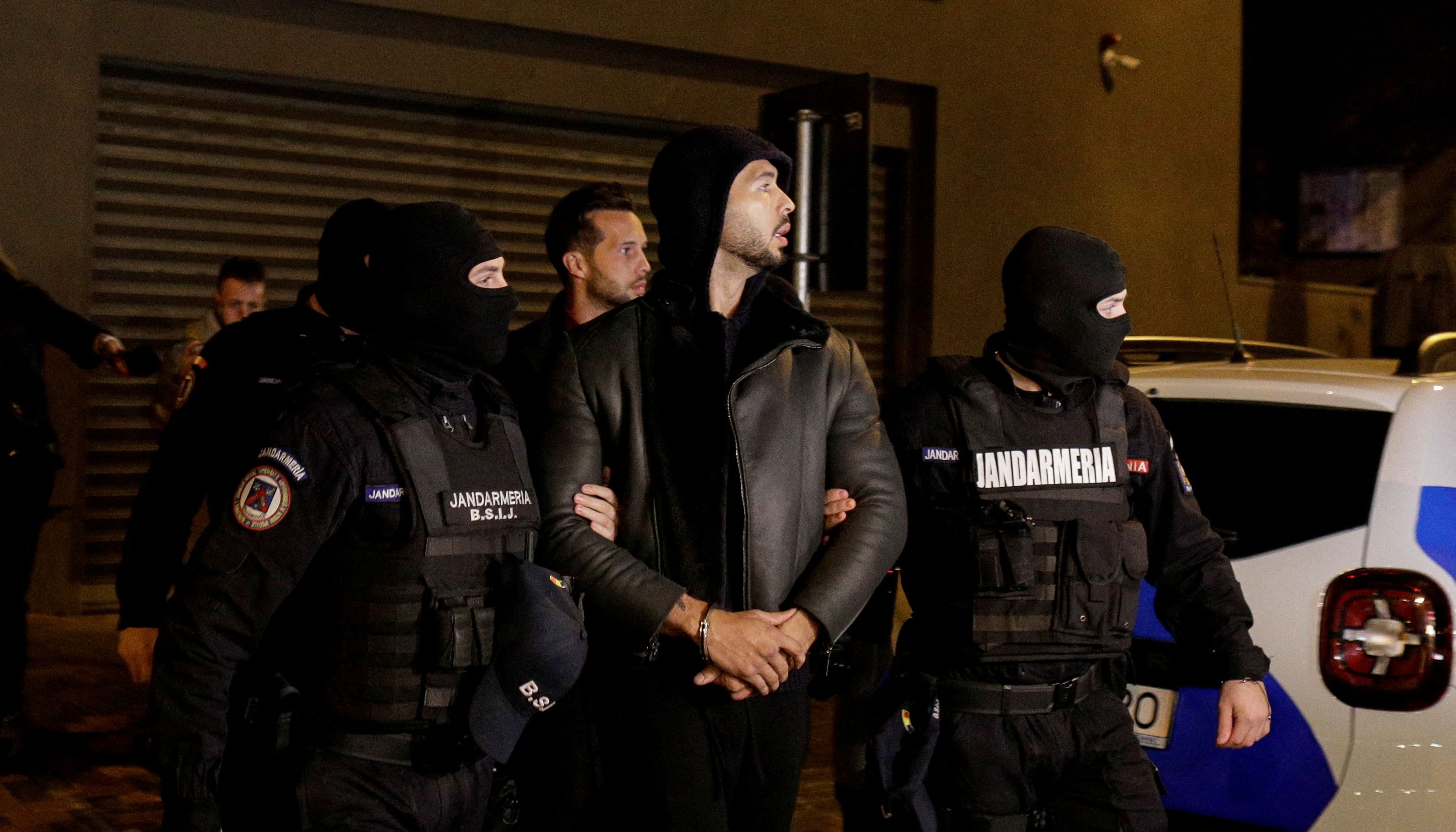 Andrew Tate and Tristan Tate are escorted by police officers outside the headquarters of the Directorate for Investigating Organized Crime and Terrorism in Bucharest (DIICOT) after being detained for 24 hours, in Bucharest,\u00a0Romania, December 29, 2022. Inquam Photos/Octav Ganea via REUTERS ATTENTION EDITORS - THIS IMAGE WAS PROVIDED BY A THIRD PARTY. ROMANIA OUT. NO COMMERCIAL OR EDITORIAL SALES IN ROMANIA