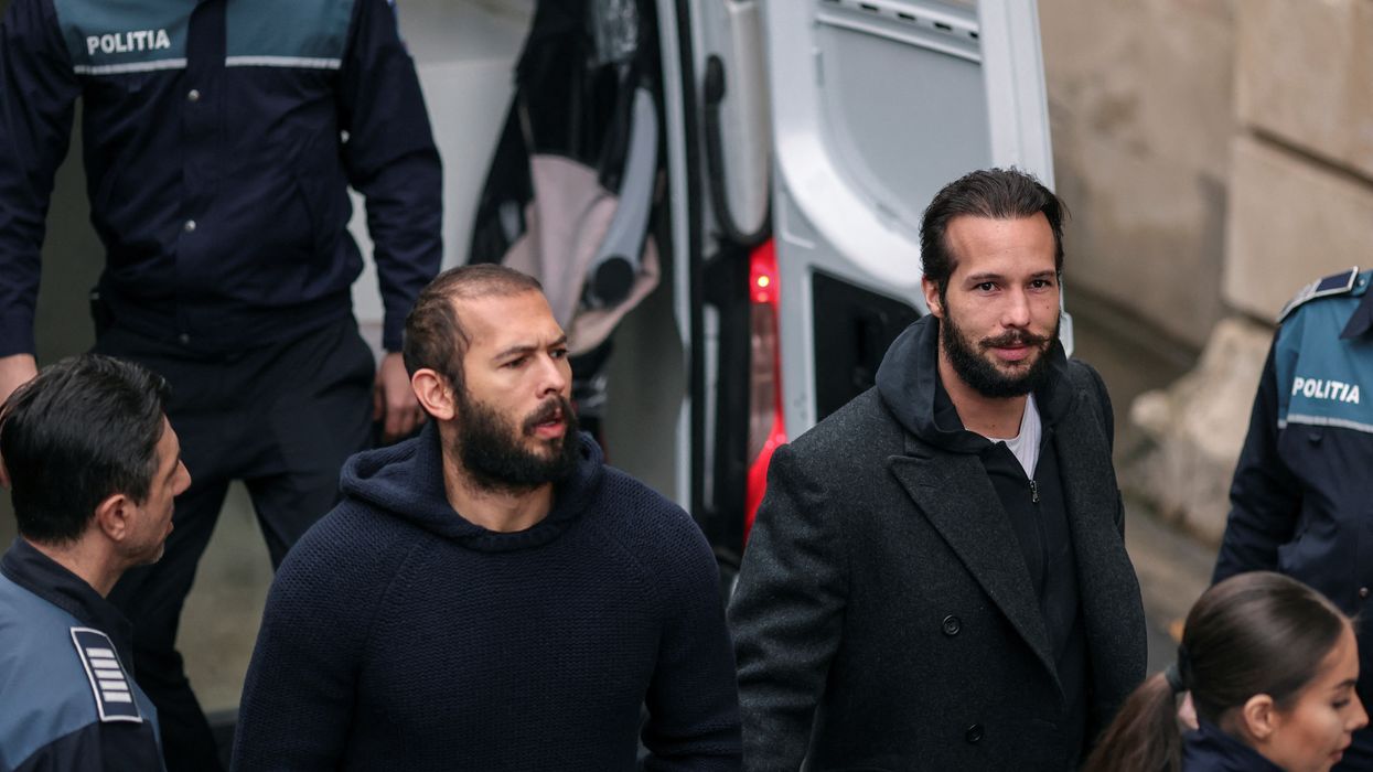 Andrew Tate and Tristan Tate being led out of a police van