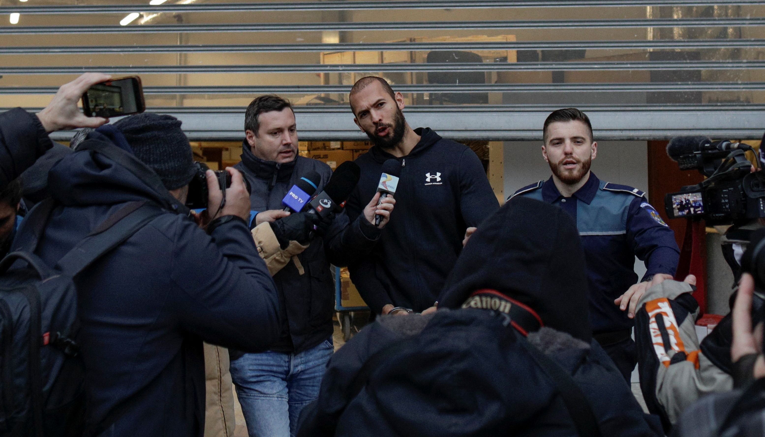 Andrew Tate answers questions from the media while being escorted by police officers outside the headquarters of the Directorate for Investigating Organized Crime and Terrorism, in Bucharest, Romania, January 25, 2023. Inquam Photos/Octav Ganea via REUTERS ATTENTION EDITORS - THIS IMAGE WAS PROVIDED BY A THIRD PARTY. ROMANIA OUT. NO COMMERCIAL OR EDITORIAL SALES IN ROMANIA