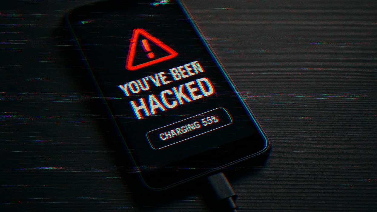 Android phone with a "You've been hacked" notification on screen while charging