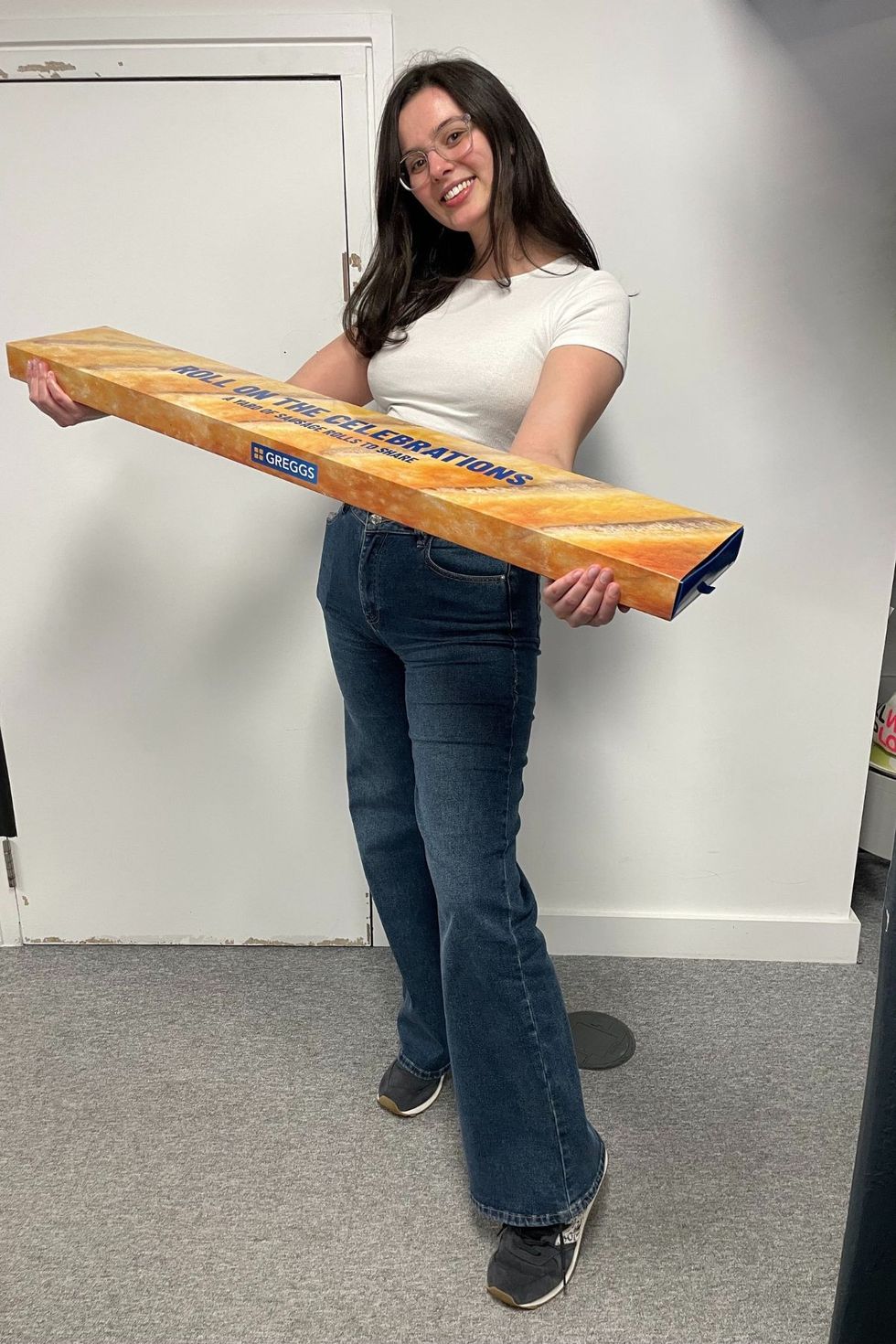 Anna holding a box of Greggs sausage rolls