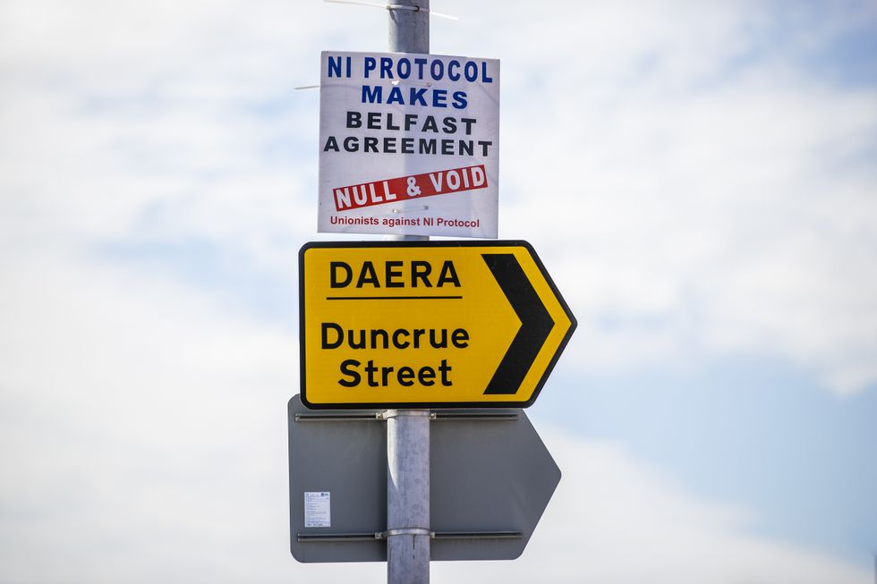 Anti NI Protocol sign above a sign for the Northern Ireland Department of Agriculture, Environment and Rural Affairs (DAERA) site on Duncrue Street in Belfast.