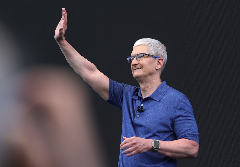 Apple CEO Tim Cook waves to crowds at the WWDC conference