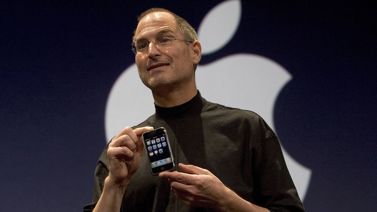 apple co-founder steve jobs holding the original iphone on-stage in 2007