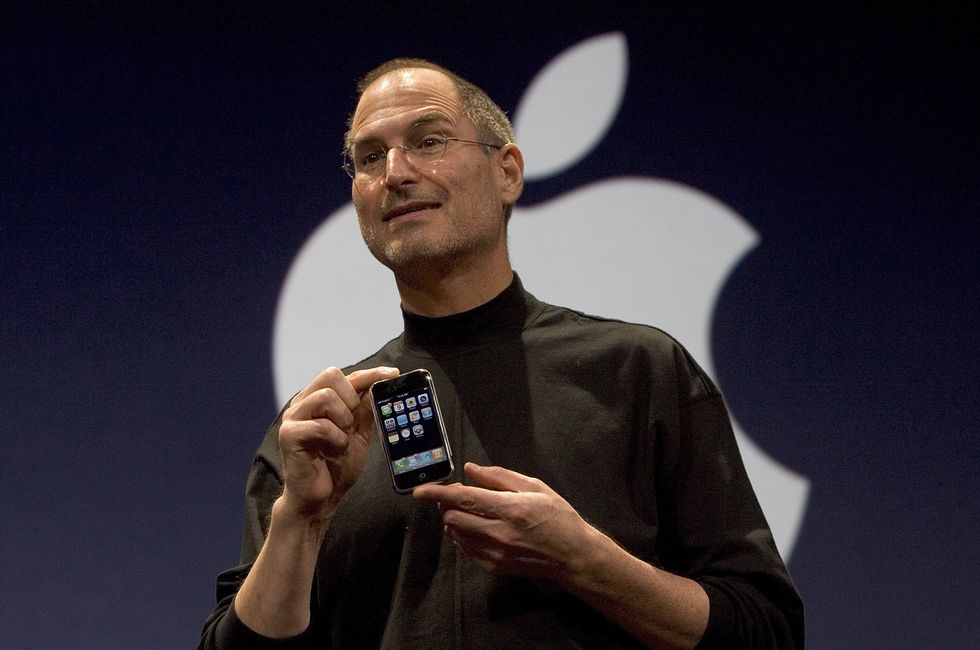 apple co-founder steve jobs holding the original iphone on-stage in 2007