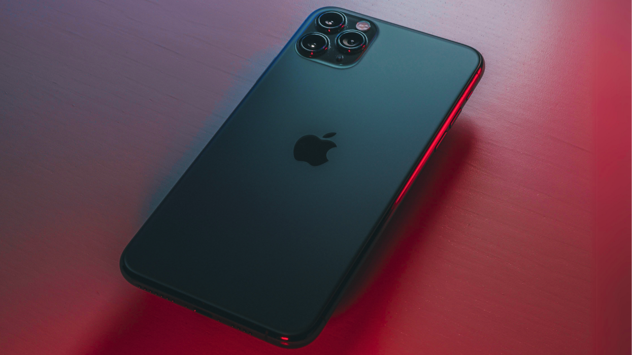 apple iphone 13 pro pictured facing down on a red table