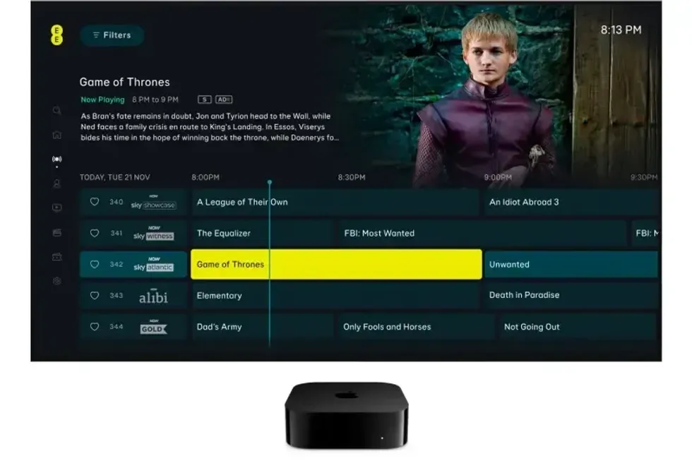 apple tv 4K box sitting in front of a television with live tv channels