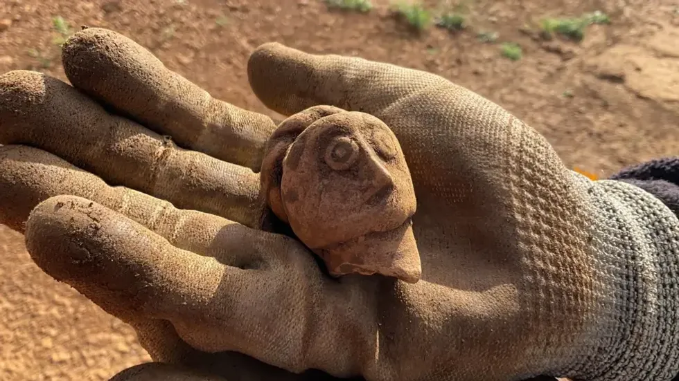 Archaeologist holds Roman artefact